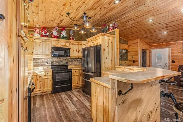 a kitchen with stainless steel appliances kitchen island granite countertop a refrigerator and a stove top oven