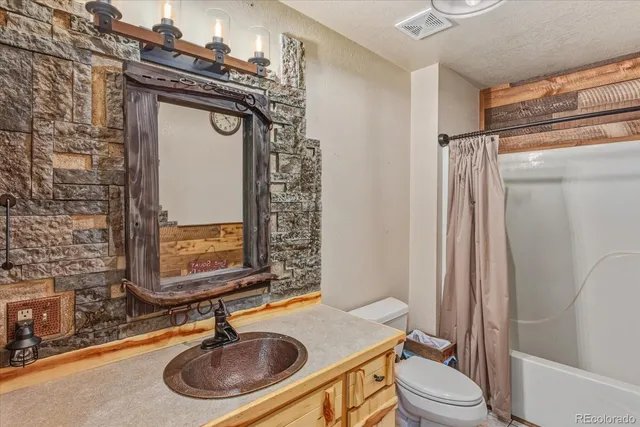 a bathroom with a sink a toilet a mirror and shower