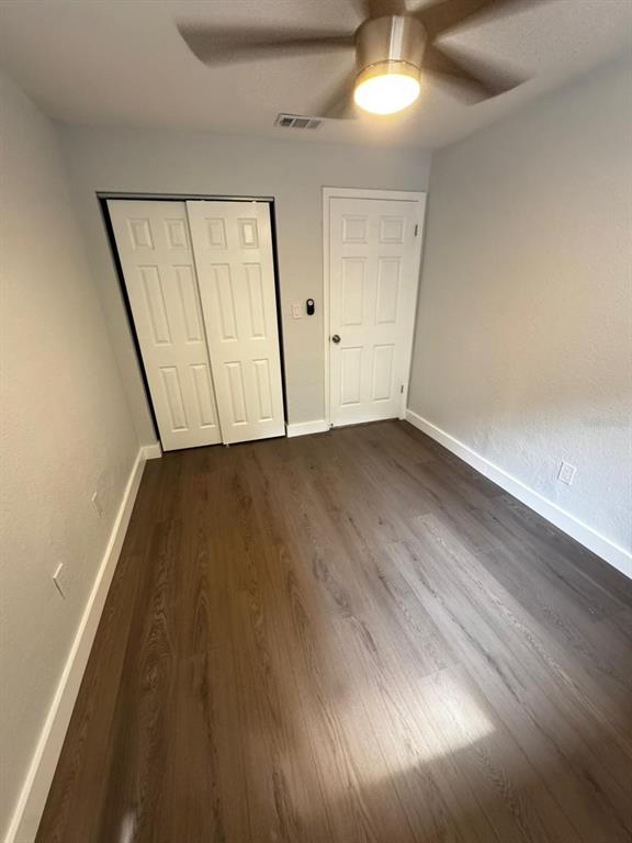836 Southwest 64th Terrace, Unit A Gainesville, FL 32607 - Photo 4 of 13 an empty room with wooden floor and windows