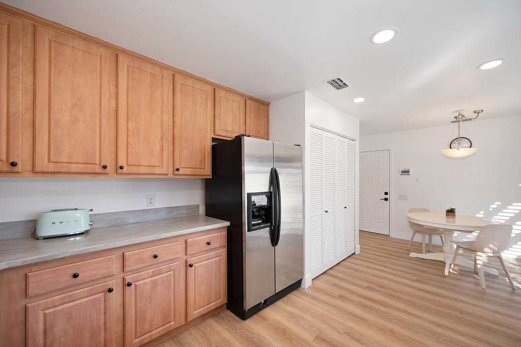 224 East Ranch Road Sacramento, CA 95825 - Photo 38 of 65 a kitchen with stainless steel appliances granite countertop a refrigerator a sink dishwasher and white cabinets with wooden floor