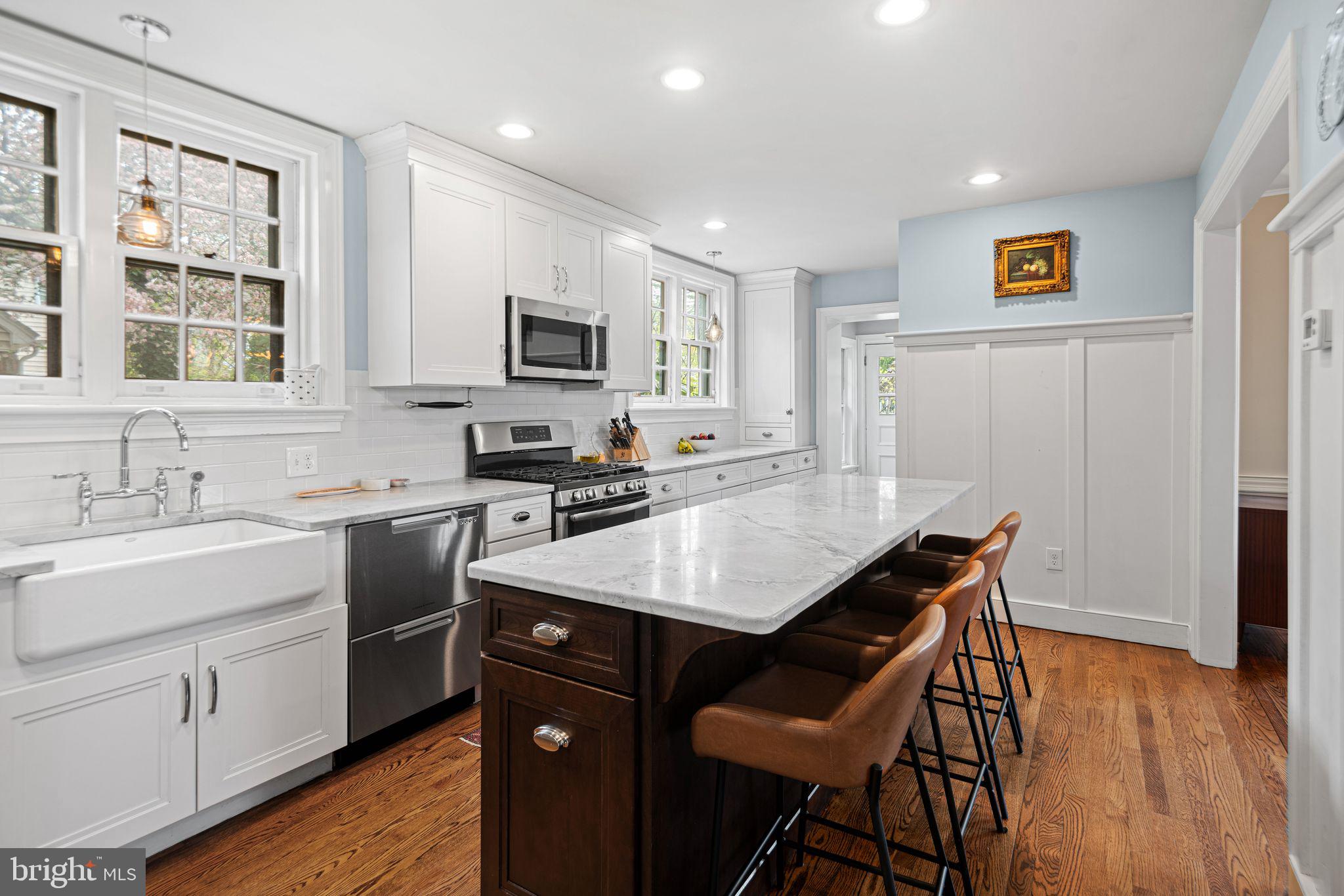 721 Rugby Road Bryn Mawr, PA 19010 - Photo 11 of 38 a kitchen with a stove a sink a microwave a dining table and chairs
