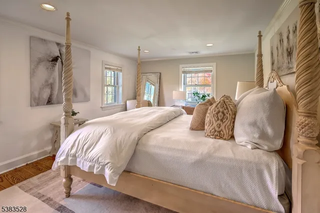 a large white bed in a small room next to a window
