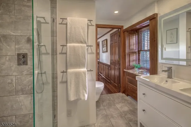 a bathroom with a double vanity sink a large mirror and shower