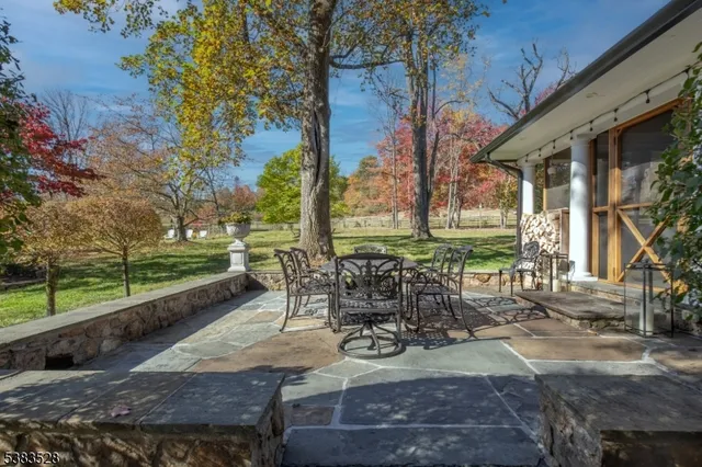 a view of a patio with table and chairs and couches with wooden fence and floor