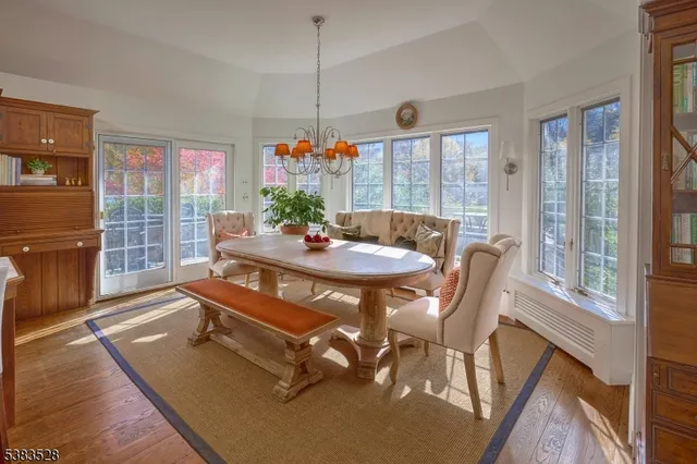 a dining room with furniture a chandelier and wooden floor