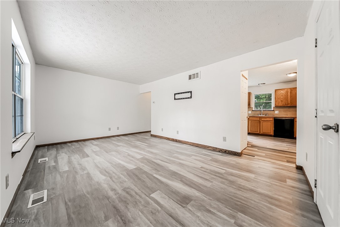 761 Garfield Street Akron, OH 44310 - Photo 8 of 31 Unfurnished living room with light wood-style flooring and a textured ceiling