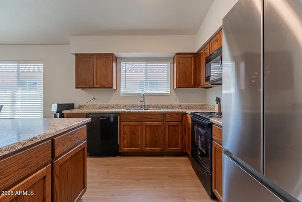 a kitchen with stainless steel appliances granite countertop a sink stove and refrigerator