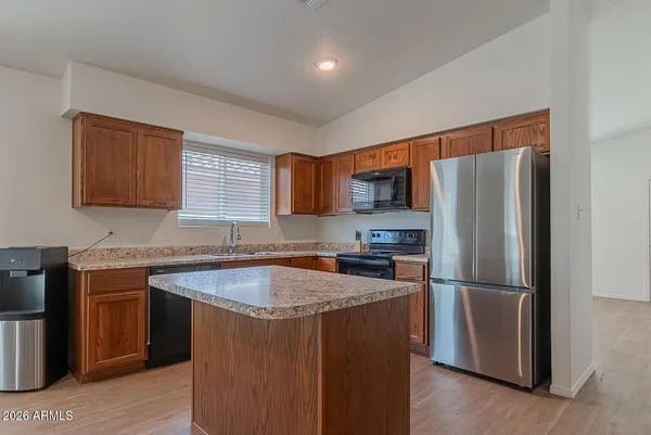 a kitchen with stainless steel appliances granite countertop a refrigerator a sink and a stove