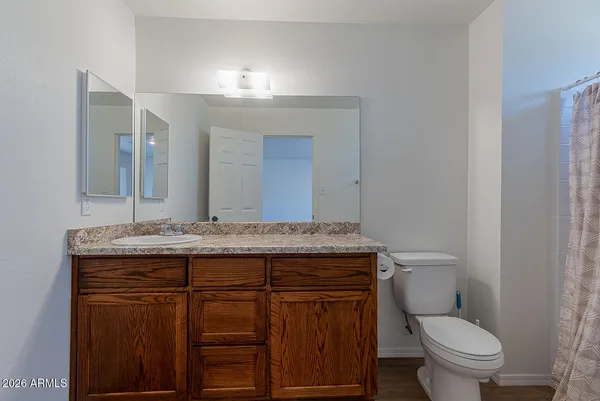 a bathroom with a granite countertop toilet sink and mirror