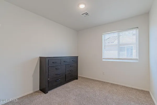 an empty room with windows and cabinet