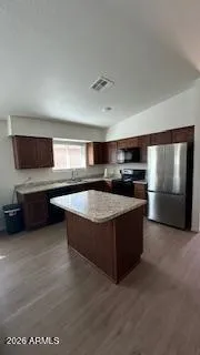 a kitchen with stainless steel appliances granite countertop a stove a sink and a refrigerator