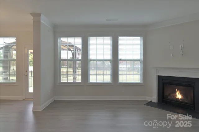 a view of an empty room with a fireplace and a window