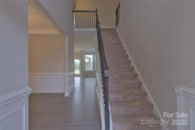 a view of a hallway with wooden floor and staircase