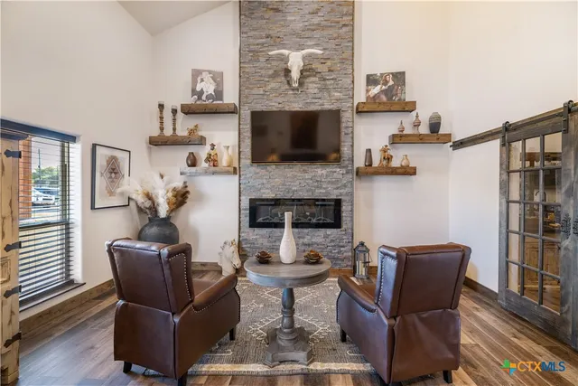 a living room with furniture a fireplace and a flat screen tv