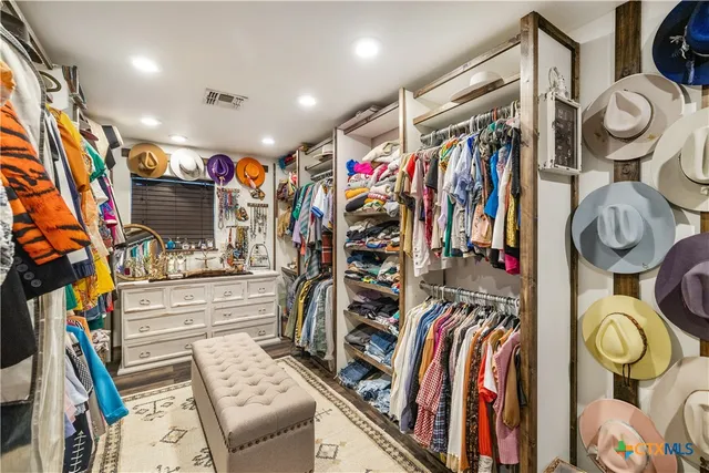 a view of walk in closet with clothes