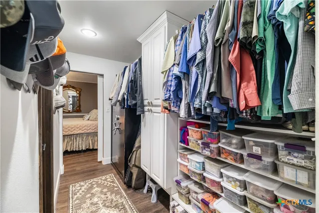 a view of walk in closet with clothes and shoes