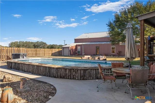 a view of a swimming pool with a lounge chairs on the terrace