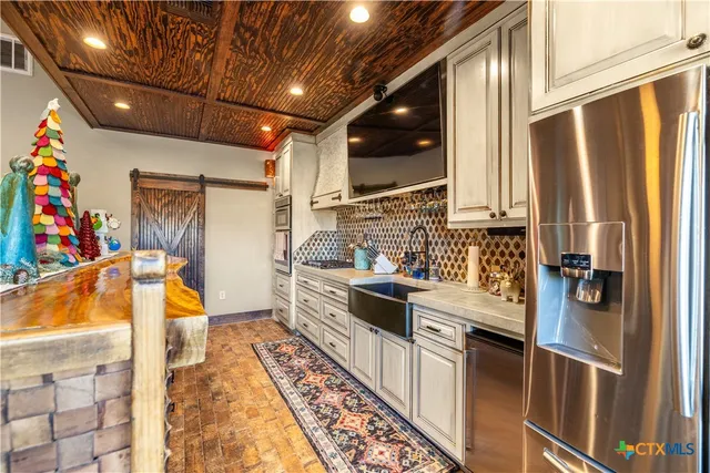 a kitchen with stainless steel appliances granite countertop a sink and a refrigerator