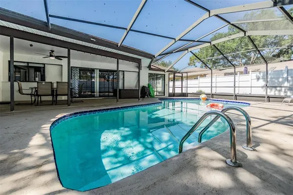 a view of a swimming pool with a lounge chairs in a patio