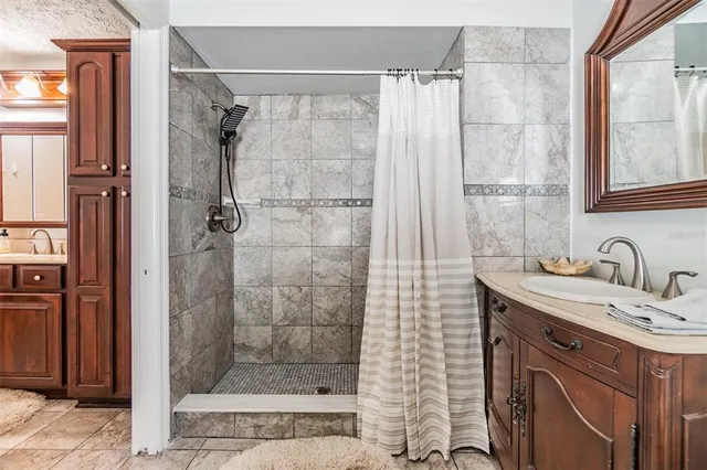 a bathroom with a sink a shower and a mirror