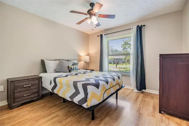 a bedroom with a bed and a ceiling fan