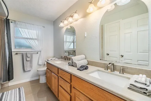 a spacious bathroom with a double vanity sink a mirror and a bathtub