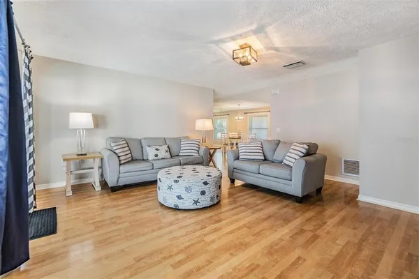 a living room with furniture and a wooden floor