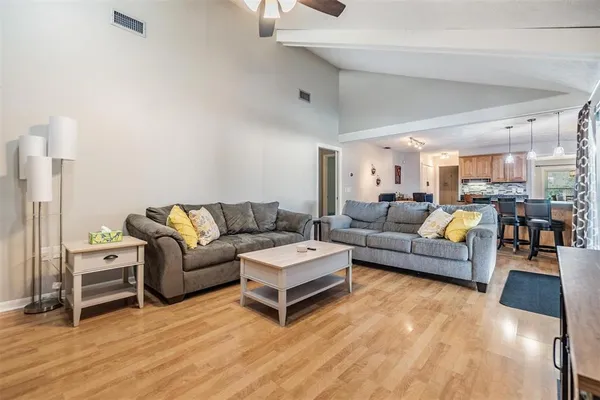 a living room with furniture and a wooden floor