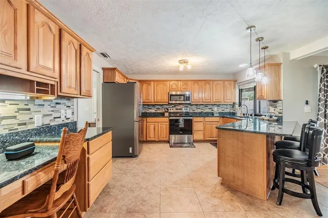 a kitchen with stainless steel appliances granite countertop a refrigerator stove microwave and sink