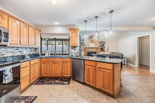 a kitchen with stainless steel appliances granite countertop a stove a sink and a refrigerator