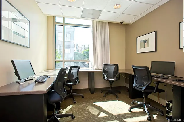a view of a workspace with furniture and a window