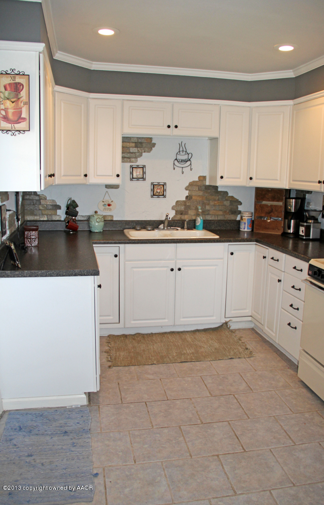 5016 South Bonham Street Amarillo, TX 79110 - Photo 12 of 31 a kitchen with granite countertop a sink a stove and cabinets