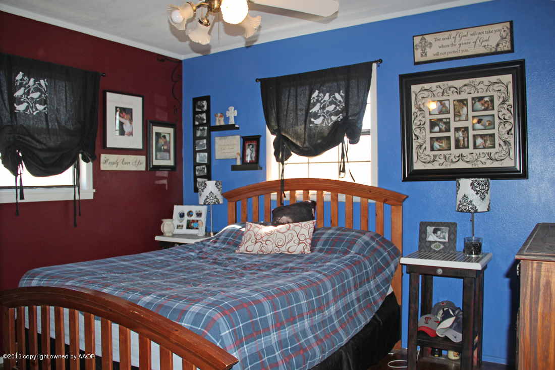 5016 South Bonham Street Amarillo, TX 79110 - Photo 14 of 31 a bedroom with a bed a painting on the wall and a potted plant