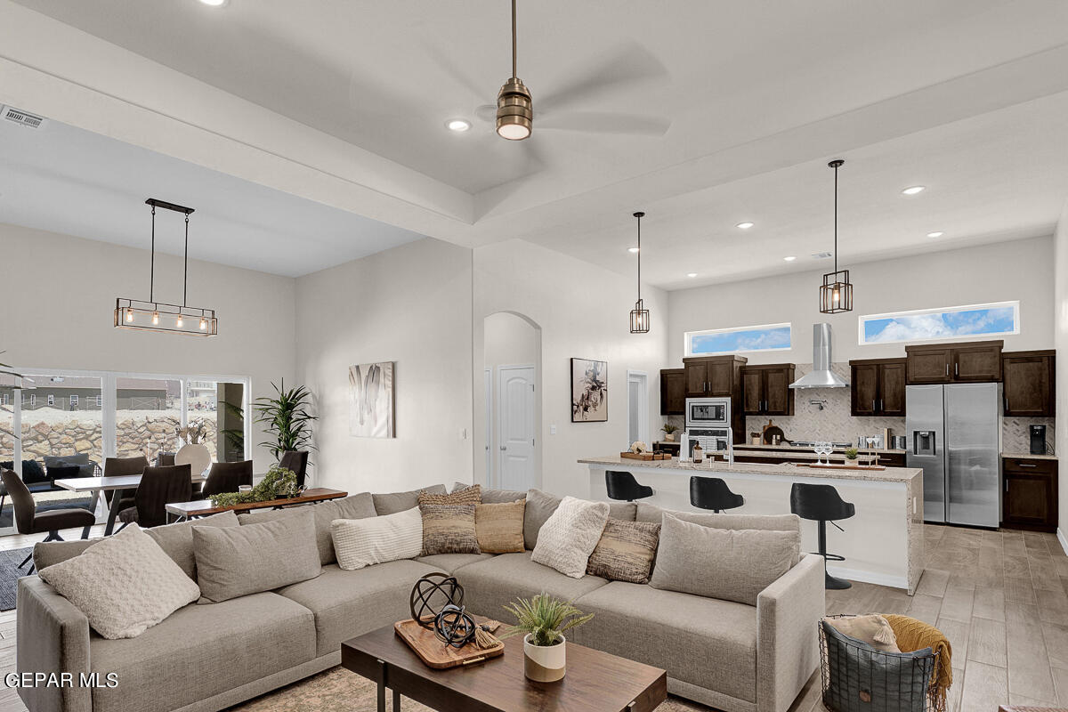 7625 Enchanted Ridge Drive El Paso, TX 79911 - Photo 27 of 57 a living room with furniture a kitchen view and a chandelier