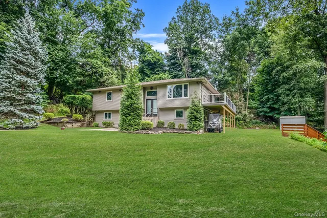 a front view of a house with a yard and trees