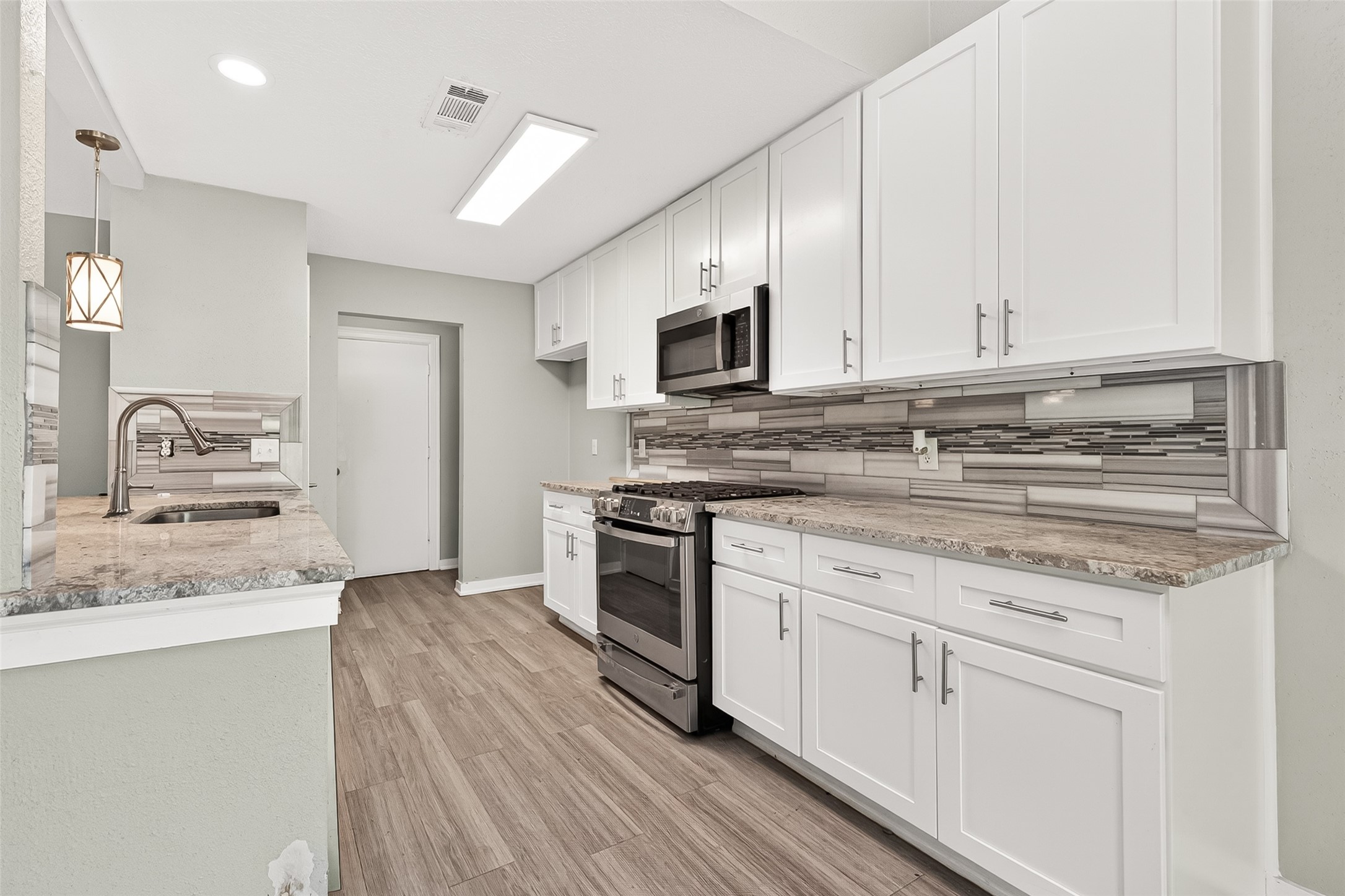 9507 Secretariat Drive Houston, TX 77065 - Photo 16 of 41 a kitchen with granite countertop a sink stainless steel appliances and white cabinets