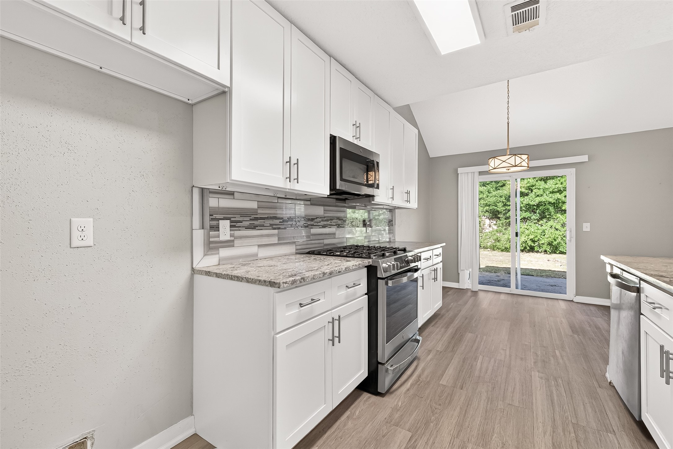 9507 Secretariat Drive Houston, TX 77065 - Photo 19 of 41 a kitchen with stainless steel appliances granite countertop a stove a sink dishwasher and a microwave oven with wooden floor