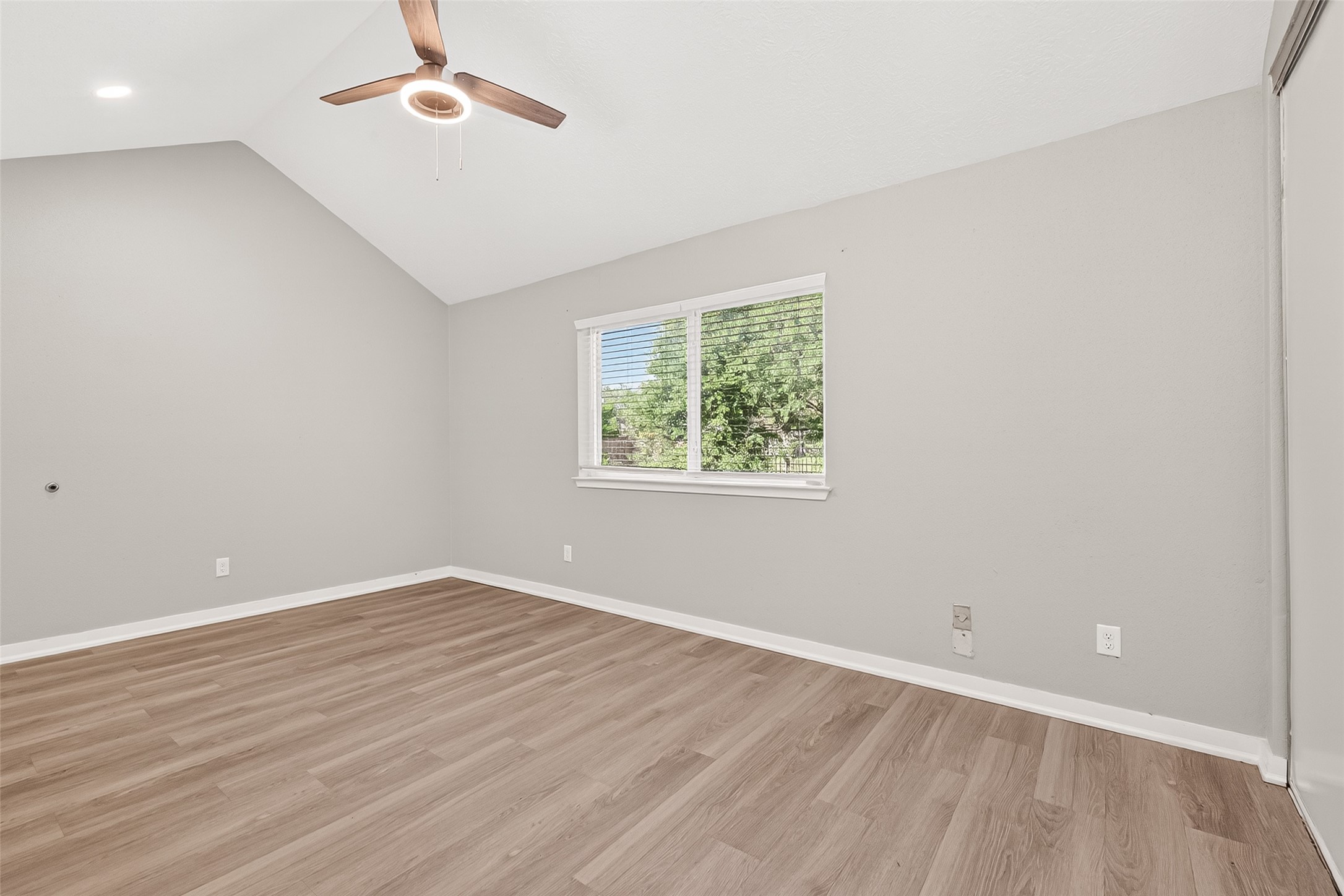 9507 Secretariat Drive Houston, TX 77065 - Photo 25 of 41 an empty room with wooden floor chandelier fan and windows