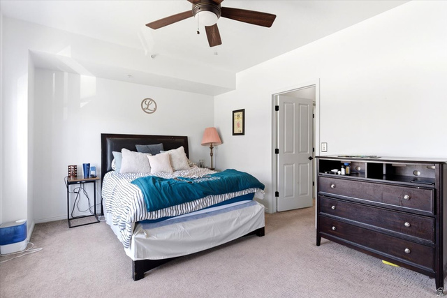 161 25th Street, Unit 6B Ogden, UT 84401 - Photo 10 of 20 Bedroom featuring neutral carpeting, a white door with dark hardware, and a ceiling fan with light fixture