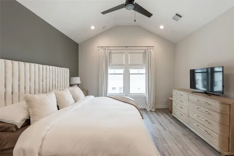 a spacious bedroom with a large bed and a flat screen tv