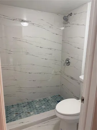 a bathroom with a toilet and a shower