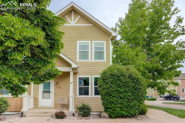 a front view of a house with a yard and potted plants