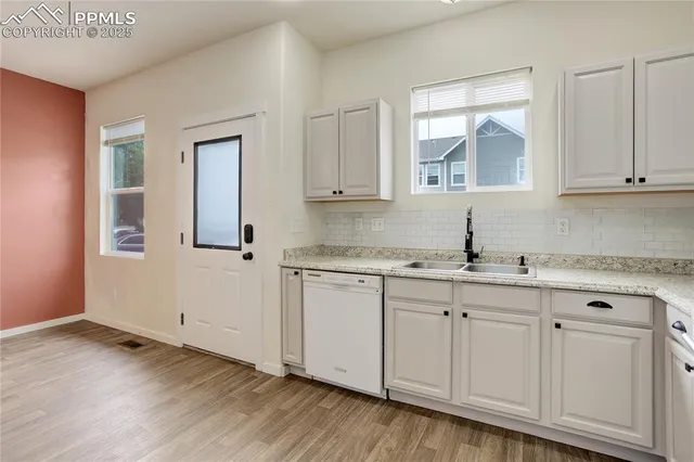 a kitchen with granite countertop white cabinets and sink