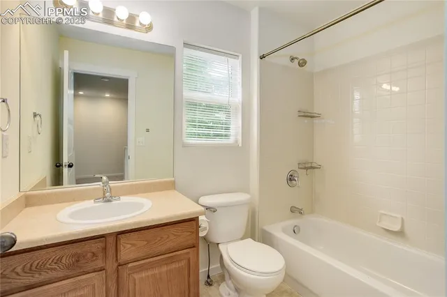 a bathroom with a granite countertop sink a toilet and shower