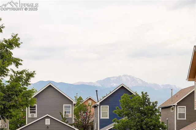 a view of a house with a yard and large trees
