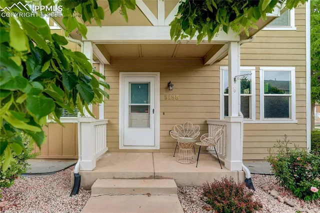 a view of house with outdoor seating and a potted plant
