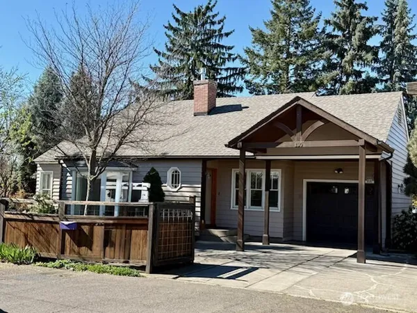 a front view of a house with a tree