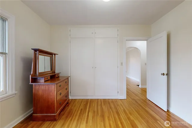 a bedroom with a bed and wooden floor