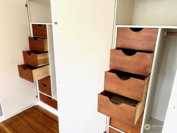 an empty room with wooden floor and cabinet