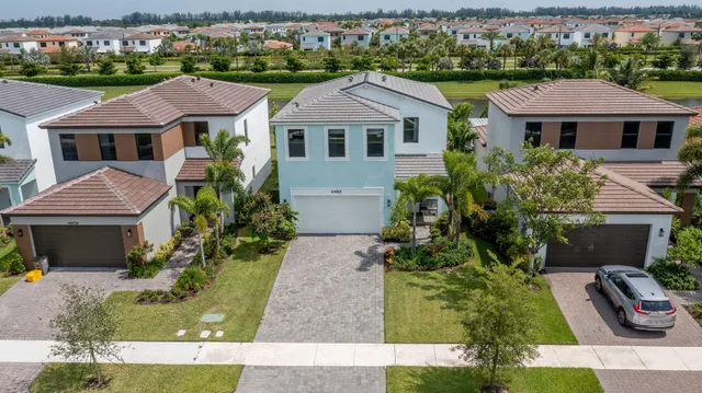 a row of palm trees in front of house